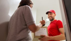 deliveryman and customer with parcel boxes at home
