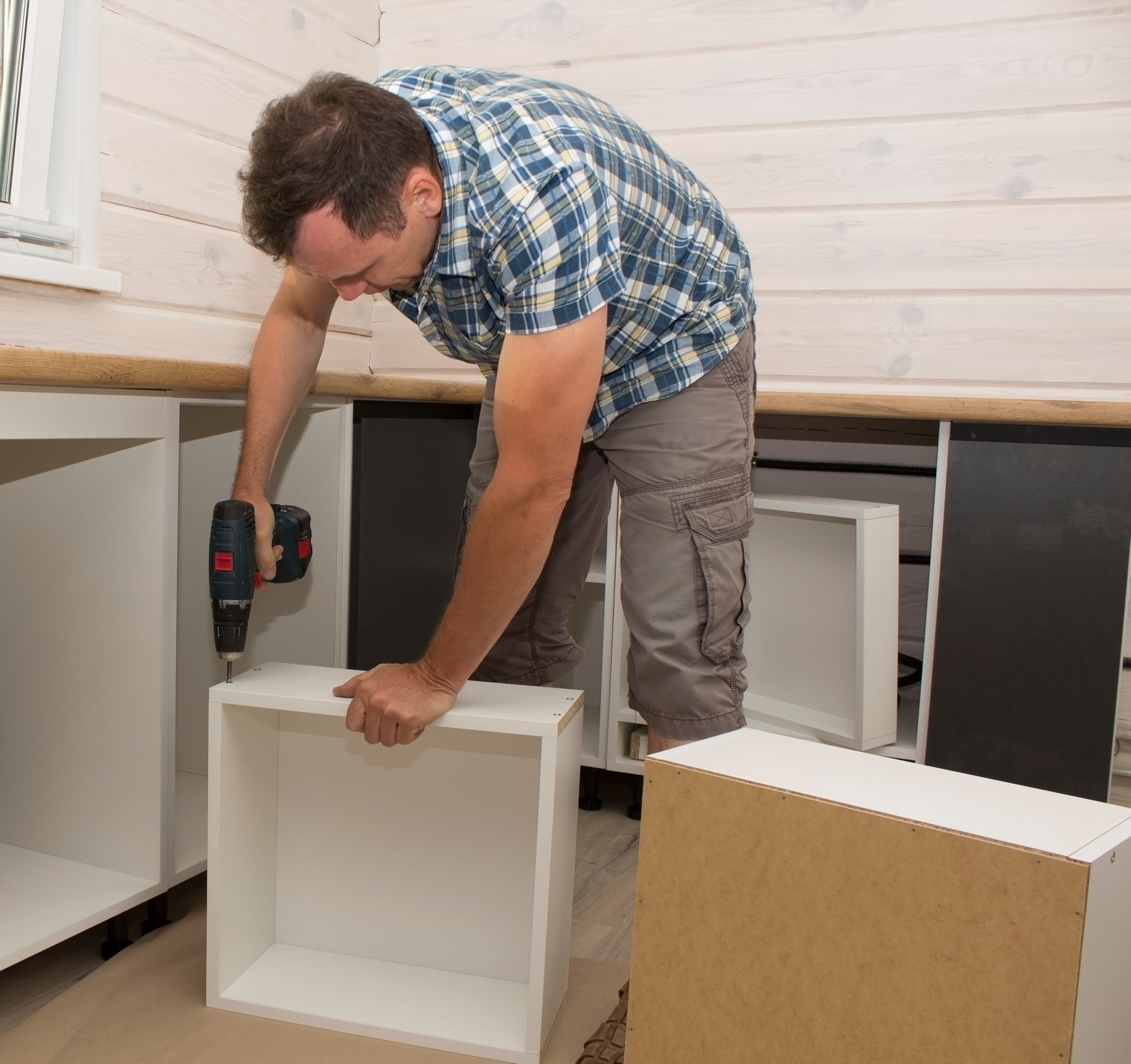 Furniture assembler assembles kitchen furniture in a private house