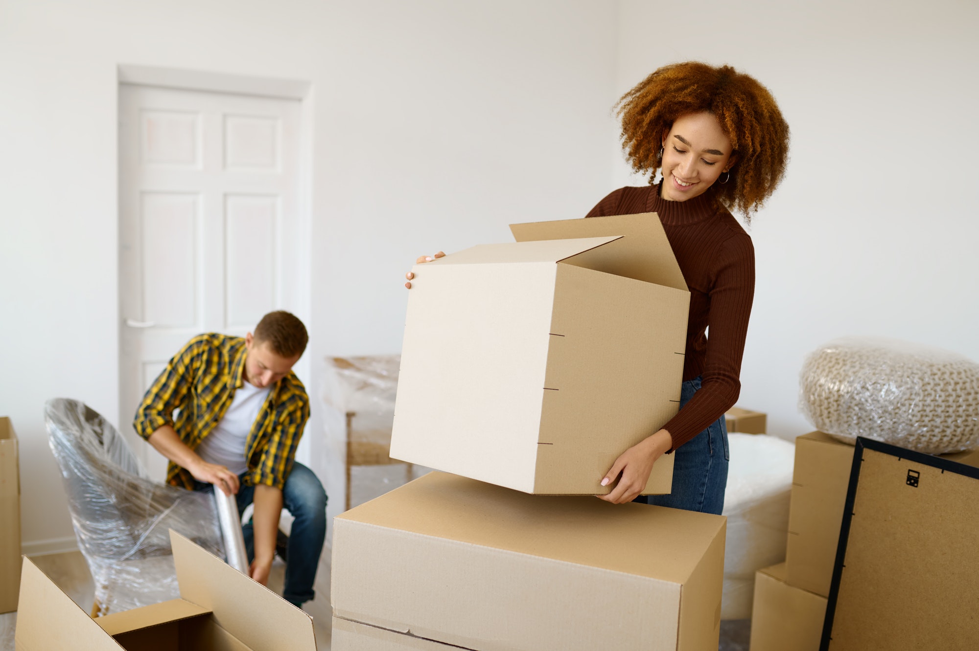 Happy couple packing beginnings before home moving